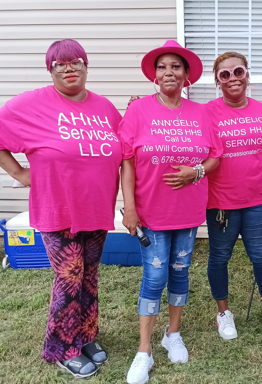 Three women of Ann'gelic Hands standing together in their pink shirts